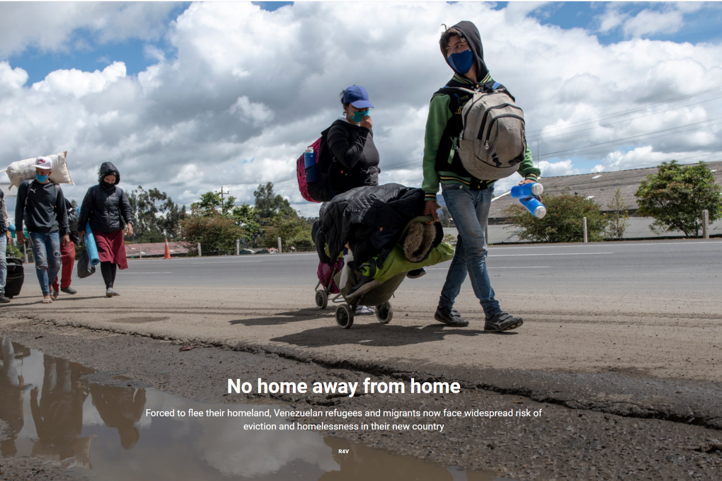 Five venezuelan refugees and migrants walking down the road with their luggage. 