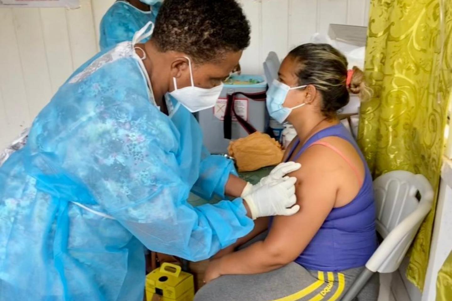 Woman receiving a COVID-19 vaccination from a health care worker