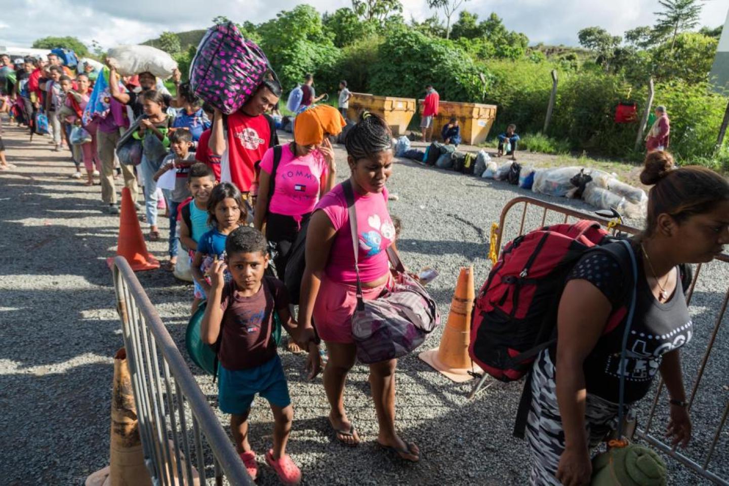 Refugiados e migrantes da Venezuela entram em um dos abrigos instalados pelo governo brasileiro em Pacaraima